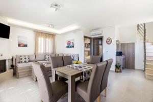 a dining room and living room with a table and chairs at Villa Lefkopetra in Triopetra