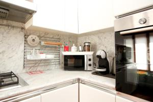 a kitchen with white marble walls and a black microwave at Guest House Rossana in Reggio Emilia +12 photos