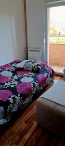 a bedroom with a bed with a floral comforter at Apartmani Katarina in Donje Čičevo