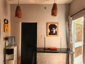 ein Zimmer mit einem Tisch und einem Bild an der Wand in der Unterkunft RÉSIDENCE PRIVÉE 1 Chambre avec Salon, Cuisine Équipée, Climatisation, Wifi et Cour Individuelle in Ouagadougou
