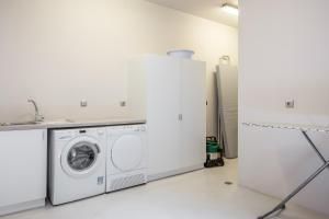 a white laundry room with a washer and dryer at Aetos Cave Villa With Sunset in Mylopotas