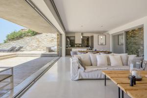 a living room with a couch and a table at Aetos Cave Villa With Sunset in Mylopotas