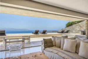 a living room with a couch and a view of the ocean at Aetos Cave Villa With Sunset in Mylopotas