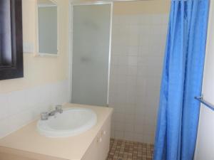 a bathroom with a sink and a blue shower curtain at Leigh Creek Outback Resort in Leigh Creek +19 photos