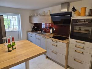a kitchen with a wooden table with two bottles of wine at NEU! Über den Dächern von Mücheln in Mücheln
