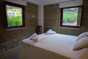 a bedroom with a bed with towels on it at Casa da Alufinha in São João da Fontoura +26 photos