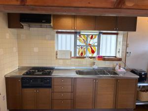 a kitchen with a sink and a stove and a window at ハルちゃん Haruchan Stay by noRo bagel 無料駐車場付 制限あり in Zushi