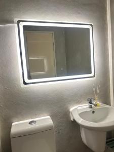 a bathroom with a mirror and a toilet and a sink at JB's Space in Cagayan de Oro