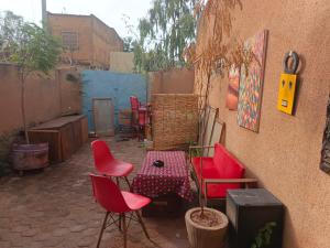eine Terrasse mit Stühlen und einem Tisch und einer Wand in der Unterkunft RÉSIDENCE PRIVÉE 1 Chambre avec Salon, Cuisine Équipée, Climatisation, Wifi et Cour Individuelle in Ouagadougou