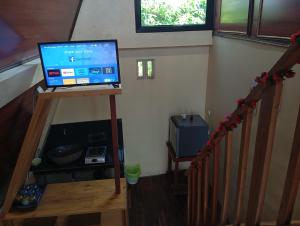 a television sitting on top of a stand in a room at Agora Home in Wonosobo