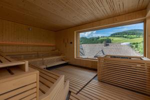 an empty room with a large window in a cabin at Sackmann Design Genuss & SPA Resort in Baiersbronn
