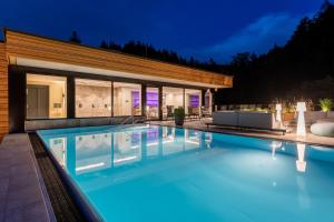 a swimming pool in front of a house at Sackmann Design Genuss & SPA Resort in Baiersbronn