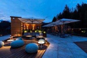 a patio with tables and umbrellas at night at Sackmann Design Genuss & SPA Resort in Baiersbronn