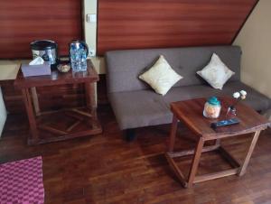 a living room with a couch and two tables at Agora Home in Wonosobo