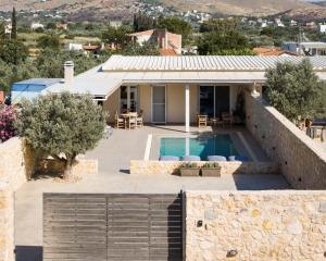 a villa with a swimming pool and a house at Olive Tree House in Anavyssos