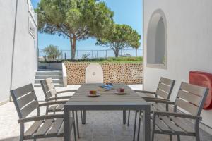 a wooden table and chairs on a patio at Bella Santorini Hotel in Perivolos