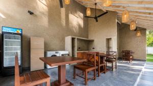 a restaurant with wooden tables and chairs and a kitchen at The Oceans Edge in Dodanduwa