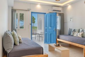 a living room with a blue door and a couch at Bella Santorini Hotel in Perivolos +201 photos