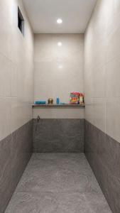 a tiled shower with a shelf on a wall at The Heritage Eco Stay in Bikaner