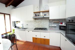 a kitchen with white cabinets and a stove top oven at Guest House Rossana in Reggio Emilia