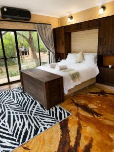 a bedroom with a large bed and a large window at Wonderviews Hedgehog in Marloth Park +53 photos