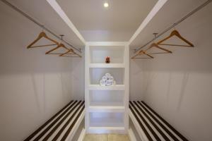 a walk in closet with white shelves at Villa Thuya - 3 Bedroom Oceanfront Villa with Pool in Balapitiya +53 photos