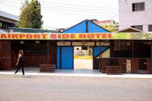 a woman walking in front of an airport side hotel at Airport Side Hotel in Accra