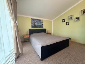 a bedroom with a large bed and a window at Harmony Haven - Spacious 4BR House with Free Parking in Cluj-Napoca