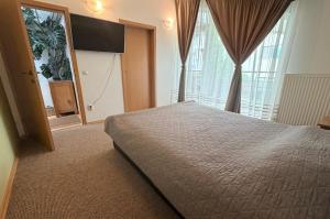a bedroom with a bed and a large window at Harmony Haven - Spacious 4BR House with Free Parking in Cluj-Napoca