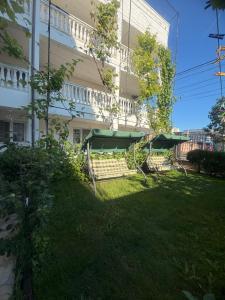 a building with a green umbrella in the grass at Casa Ciobi in 2 Mai +38 photos