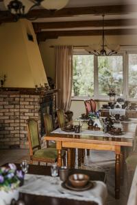 a dining room with tables and chairs and a fireplace at Dworek Biebrzański in Augustów