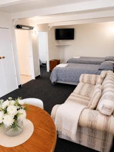 a bedroom with a bed and a couch and a table at The Cave Motel in Levin