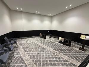 a room with chairs and tables and a room with black walls at فندق فاليا in Al Kharj