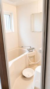 a bathroom with a white tub and a toilet at A forest guesthouse with barbecue facilities in Nikko +14 photos