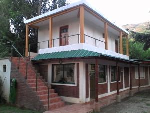 uma pequena casa com telhado verde e escadas em Posada A Lo De Santys em Villa Independencia