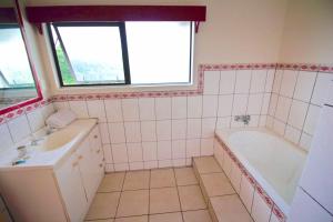 a bathroom with a tub and a sink and a bath tub at Tonga Holiday Villa in Nuku‘alofa +34 photos