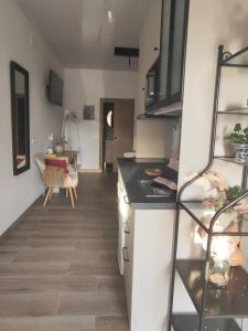 a kitchen with white cabinets and a table in a room at Magariños Apartamentos in Oia