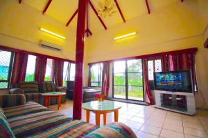 a living room with a couch and a tv at Tonga Holiday Villa in Nuku‘alofa