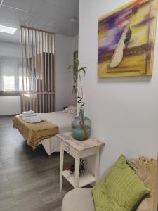 a room with a bed and a table with a vase on it at Magariños Apartamentos in Oia
