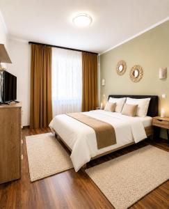 a bedroom with a large bed and a television at Ama Residence 1 in Deva