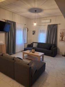 a living room with two couches and a coffee table at Meteora view Guesthouse in Kalabaka