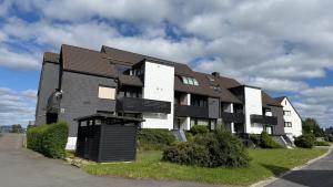 an apartment building with a black and white at Maisonette Wohnung WALDLOFT in Mehlmeisel