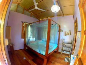 a bedroom with a canopy bed in a room at Tampat do Aman in Kudat