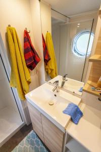 a bathroom with a sink and a mirror at Camping JOBEL in Tarnos +28 photos