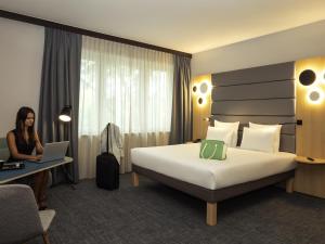 a woman sitting at a desk in a hotel room at Novotel Brussels Centre Midi in Brussels