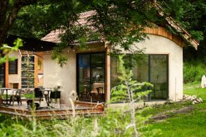 a house with glass doors and a table and chairs at Tinyhouse insolite - Au bout du chemin - 10 min de Foix in Baulou