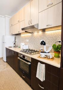 a kitchen with wooden cabinets and a stove top oven at Ama Residence 1 in Deva +3 photos