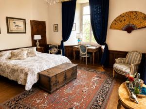 a bedroom with a bed and a table and a chair at Château de Taussac in Taussac