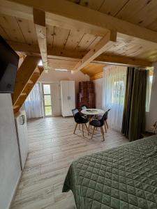 a bedroom with a bed and a table and chairs at Livada Bunicilor in Zamfireşti