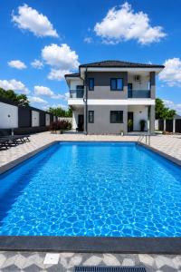 a villa with a swimming pool in front of a house at Grey House in Bucharest